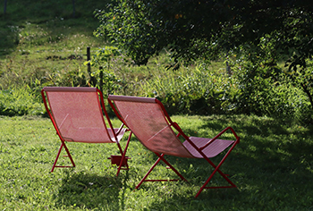 zwei rote Gartenstühle im Garten, Seilerhansenhof